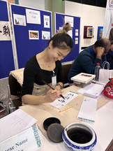 Auf einer Kulturveranstaltung des Konfuzius Institut gibt eine Lehrerin des Konfuzius Institut ihre Kalligraphiekünste zum besten.